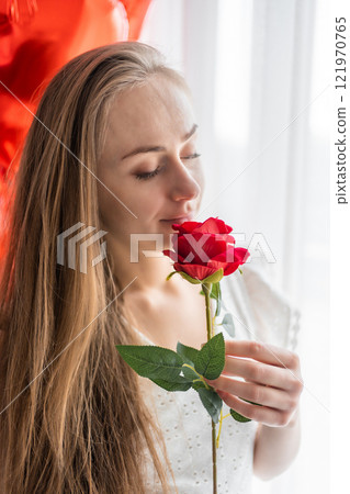 Beautiful young girl at home in bedroom in the morning enjoy valentines day celebration with heart shaped balloons Beautiful young girl at home in bedroom in the morning enjoy valentines day celebration with heart shaped balloons 121970765