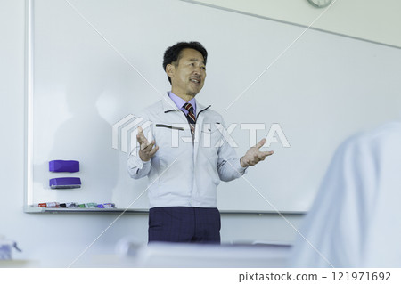 穿著工作服的中年男子在白板前說話 攝影合作:電波學園教育法人東京電子學校。 穿著工作服的中年男子在白板前說話 攝影合作:電波學園教育法人東京電子學校。 121971692