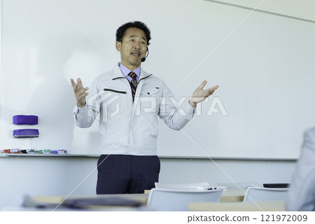穿著工作服的中年男子在白板前說話 攝影合作：電波學園教育法人東京電子學校。 121972009