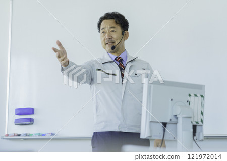 A middle-aged man in work clothes talking in front of a whiteboard. Photo courtesy of Tokyo Electronics College, Denpa Gakuen Corporation. A middle-aged man in work clothes talking in front of a whiteboard. Photo courtesy of Tokyo Electronics College, Denpa Gakuen Corporation. 121972014