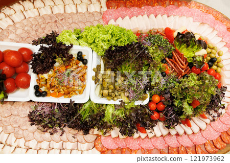 Catering platter with sliced meat, vegetables, mushrooms and olives decorating a festive table Catering platter with sliced meat, vegetables, mushrooms and olives decorating a festive table 121973962