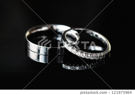 Two wedding rings showing commitment and eternal love are laying on dark background Two wedding rings showing commitment and eternal love are laying on dark background 121973964