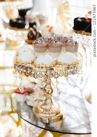 Delicious macarons and pastries decorating a luxurious candy bar buffet Delicious macarons and pastries decorating a luxurious candy bar buffet 121973967