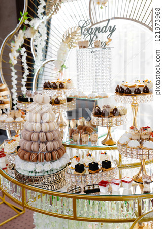 Delicious macarons and pastries decorating a luxurious candy bar buffet Delicious macarons and pastries decorating a luxurious candy bar buffet 121973968