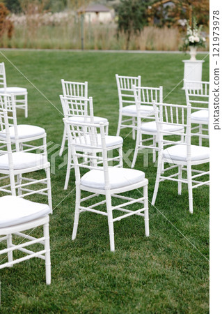 White chiavari chairs standing on lawn for wedding ceremony are waiting for guests 121973978
