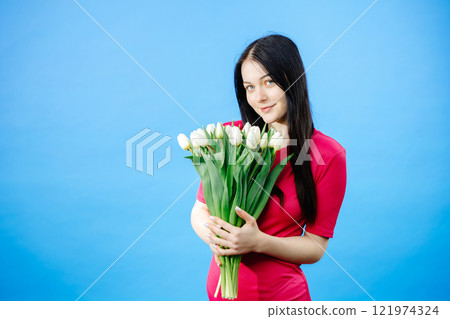 Girl with long dark hair holding white tulips on blue background Girl with long dark hair holding white tulips on blue background 121974324
