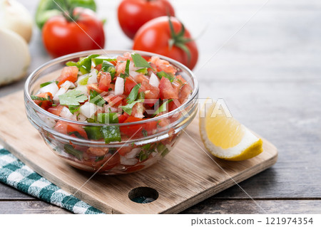 Traditional Mexican Pico de Gallo sauce in bowl on wooden table Traditional Mexican Pico de Gallo sauce in bowl on wooden table 121974354