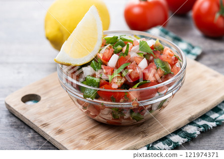 Traditional Mexican Pico de Gallo sauce in bowl on wooden table 121974371