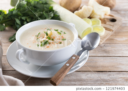 Cauliflower soup in bowl on wooden table 121974403