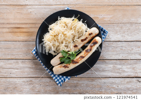 Bratwurst sausage and sauerkraut on wooden table Bratwurst sausage and sauerkraut on wooden table 121974541