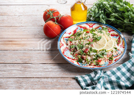Tabbouleh salad with couscous on wooden table Tabbouleh salad with couscous on wooden table 121974544