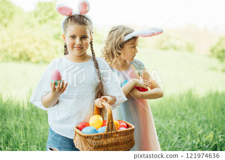 Easter egg hunt. Group Of Children Wearing Bunny Ears Running To Pick Up colorful Egg On Easter Egg Hunt In Garden. Easter tradition. Laughing children in park with basket spring concept 121974636