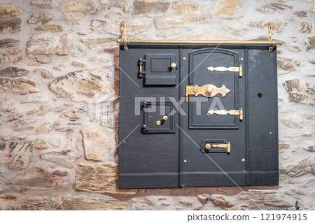 Vintage Iron Door on Rustic Stone Wall 121974915