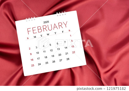 February 2025 Monthly desk calendar on red silk textile background. February 2025 Monthly desk calendar on red silk textile background. 121975182