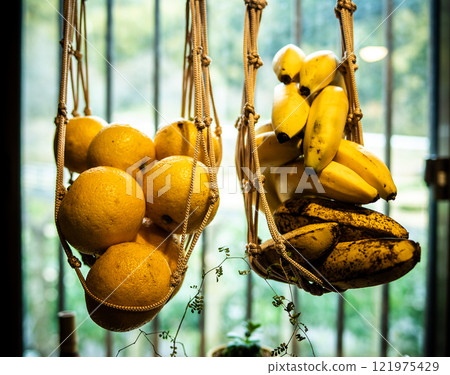 Bananas and kabosu hanging from a net 121975429