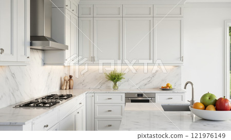 Modern kitchen interior featuring white cabinets, marble countertops, and fresh fruit arrangement in a bright setting 121976149