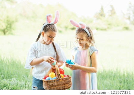 Easter egg hunt. Group Of Children Wearing Bunny Ears Running To Pick Up colorful Egg On Easter Egg Hunt In Garden. Easter tradition. Laughing children in park with basket spring concept 121977321