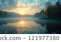 Beautiful sunrise over tranquil lake surrounded by trees on a misty morning 121977380