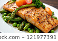 Grilled salmon served on a bed of fresh asparagus and green peas with cherry tomatoes 121977391