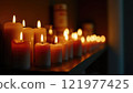 Flickering candles illuminate a peaceful setting in a dimly lit room during evening hours 121977425