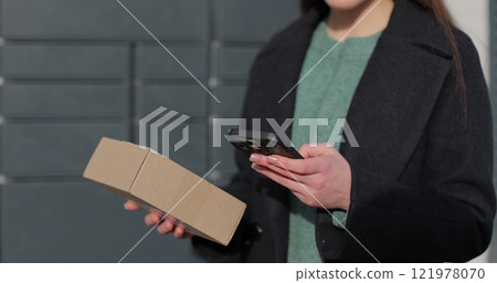 Close up woman collecting parcel from shopping locker. Mail delivery and post service, online shopping, e commerce concept. 121978070