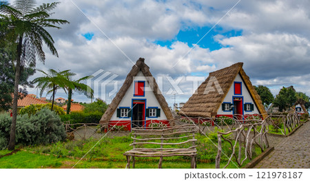 Traditional hut houses and garden of Madeira in village Santana. Sunny day in Portugal, tourist destination Traditional hut houses and garden of Madeira in village Santana. Sunny day in Portugal, tourist destination 121978187