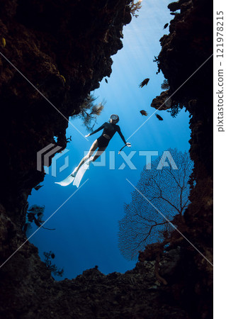 Female freediver swims in underwater cave on Menjangan island Female freediver swims in underwater cave on Menjangan island 121978215