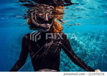 Freediver snorkeling in tropical sea with cute small fishes. Freediver snorkeling in tropical sea with cute small fishes. 121978216