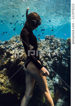Beauty freediver underwater near coral reef rocks in tropical sea. Beauty freediver underwater near coral reef rocks in tropical sea. 121978222