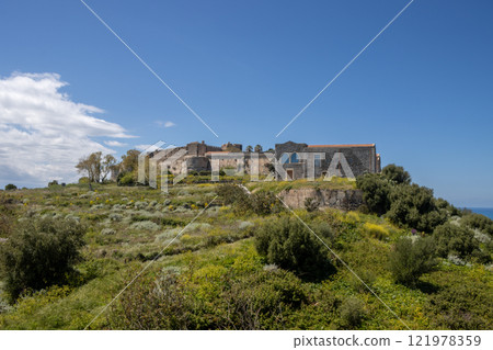 Green hill with the Milazzo Castle, Sicily, Italy 121978359