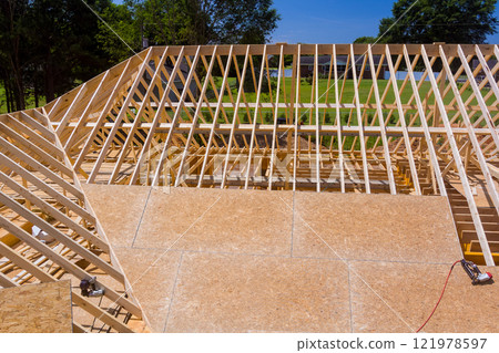 Construction workers nailing plywood new residential beams roof framing under construction house Construction workers nailing plywood new residential beams roof framing under construction house 121978597