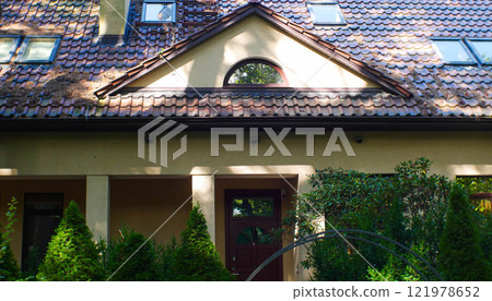 Beige house with a tiled roof and skylights nearby. The architecture of the building. Geometric correct photo 121978652