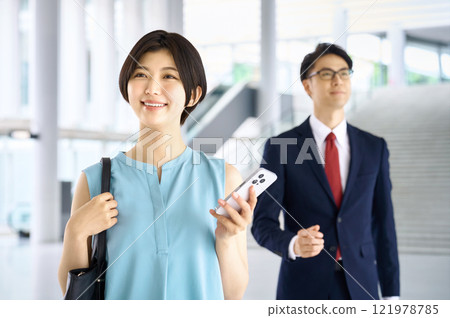 Business woman operating a smartphone in the office 121978785