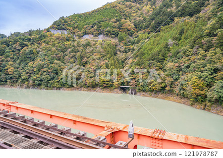 Scenery of Okuoi Rainbow Bridge at Okuoi Kojo Station dyed in autumn leaves in Kawanehon Town (Shizuoka Prefecture) 121978787