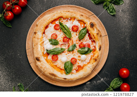 Margherita pizza with fresh basil, mozzarella, and cherry tomatoes on a rustic wooden plate Margherita pizza with fresh basil, mozzarella, and cherry tomatoes on a rustic wooden plate 121978827