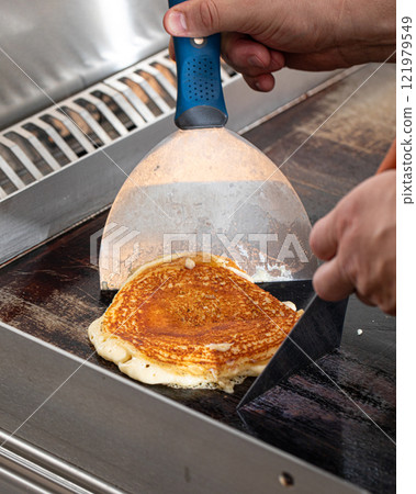 Cooking fresh pancake on black pan Cooking fresh pancake on black pan 121979549