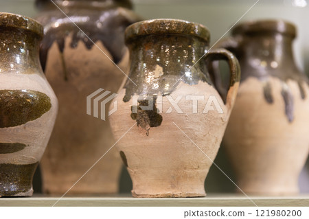 Ancient clay jugs are in antique shop 121980200