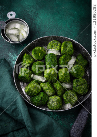 Frozen spinach green cubes in bowl 121980288