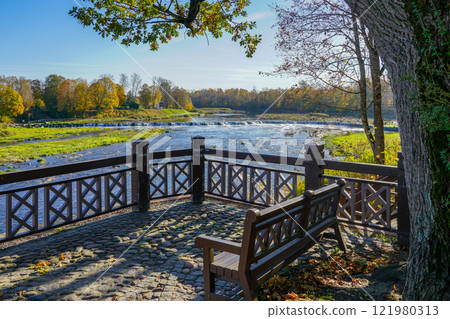 Picturesque autumn view of Europe widest waterfall on the Venta River from a historic wooden terrace Picturesque autumn view of Europe widest waterfall on the Venta River from a historic wooden terrace 121980313