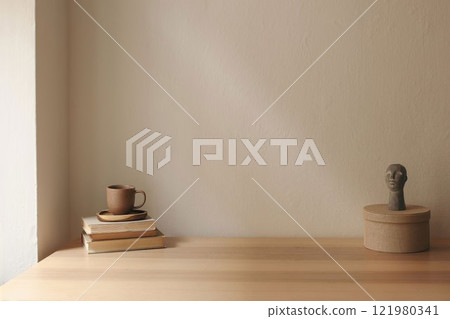 Artistic boho still life. Cup of tea, coffee, old books. Boho busta sculpture, statue. Round textile gift box. Beige wall background mockup. Empty copy space. Elegant minimal interior living room. 121980341
