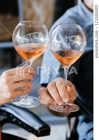 Toasting with rose wine in elegant glasses, capturing a moment of celebration and joy 121980805
