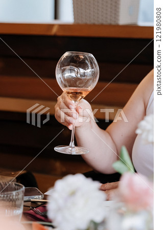 Hand holding elegant wine glass, perfect for celebrations, dining, and social gatherings Hand holding elegant wine glass, perfect for celebrations, dining, and social gatherings 121980808