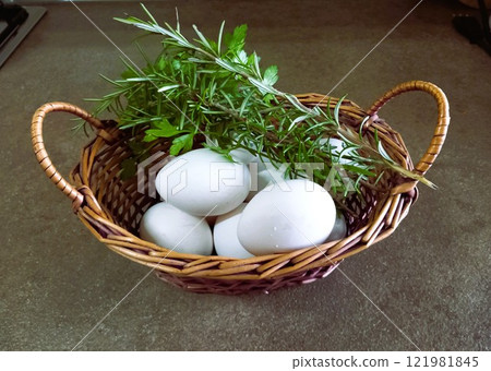 fresh white eggs in a wicker basket with herbs fresh white eggs in a wicker basket with herbs 121981845