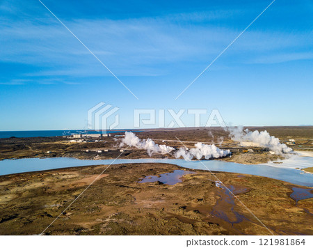 Aerial: White smoke billows over a colorful geothermal area with red soil and a crater lake in Grindavik, Iceland Aerial: White smoke billows over a colorful geothermal area with red soil and a crater lake in Grindavik, Iceland 121981864