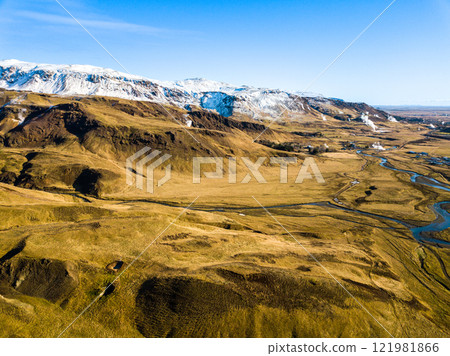 Scenic aerial panorama showcases the Hveragerdi geothermal area in Iceland, highlighting majestic mountains and bubbling hot springs. Natural beauty captivates with vibrant geothermal activity Scenic aerial panorama showcases the Hveragerdi geothermal area in Iceland, highlighting majestic mountains and bubbling hot springs. Natural beauty captivates with vibrant geothermal activity 121981866