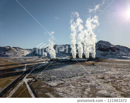 White steam billows from the geothermal power plant in Hellisheidi, Iceland, contrasting with the snowy peaks of Iceland's breathtaking winter scenery in this aerial White steam billows from the geothermal power plant in Hellisheidi, Iceland, contrasting with the snowy peaks of Iceland's breathtaking winter scenery in this aerial 121981872