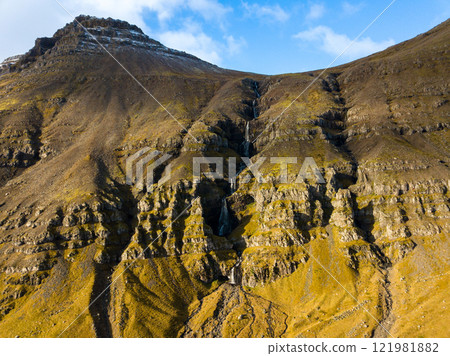 Majestic krossfoss waterfall flowing down a steep, rocky mountainside in the icelandic highlands, showcasing the raw beauty of nature Majestic krossfoss waterfall flowing down a steep, rocky mountainside in the icelandic highlands, showcasing the raw beauty of nature 121981882