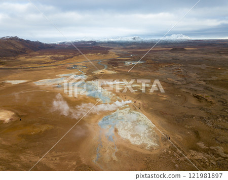 Steam billows from the geothermal area of Hverir near the Kafla vulcanic area of Iceland, highlighting vibrant mineral deposits in the foreground against a striking landscape Steam billows from the geothermal area of Hverir near the Kafla vulcanic area of Iceland, highlighting vibrant mineral deposits in the foreground against a striking landscape 121981897