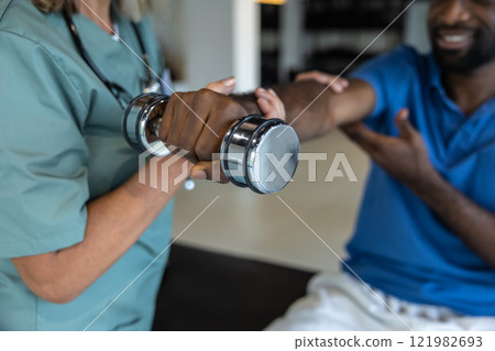 Female doctor guiding a young male patient in physical therapy 121982693