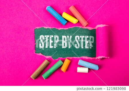Step By Step. Text under torn purple paper on a green chalkboard Step By Step. Text under torn purple paper on a green chalkboard 121983098